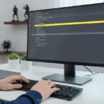 Código HTML com a tag div destacada em um monitor, sendo digitado por um desenvolvedor.